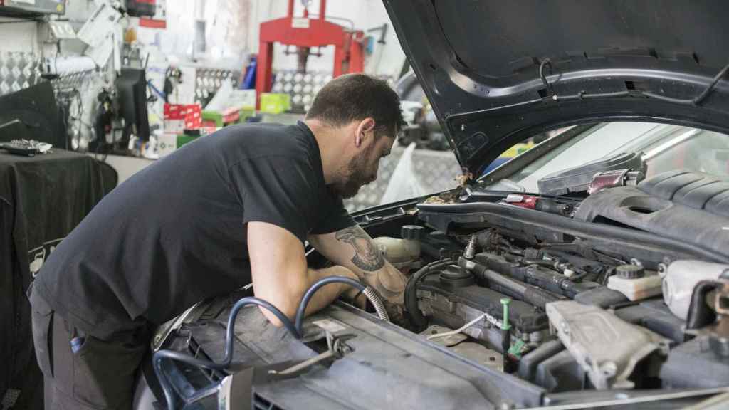 Un mecánico revisa el motor de un automóvil.