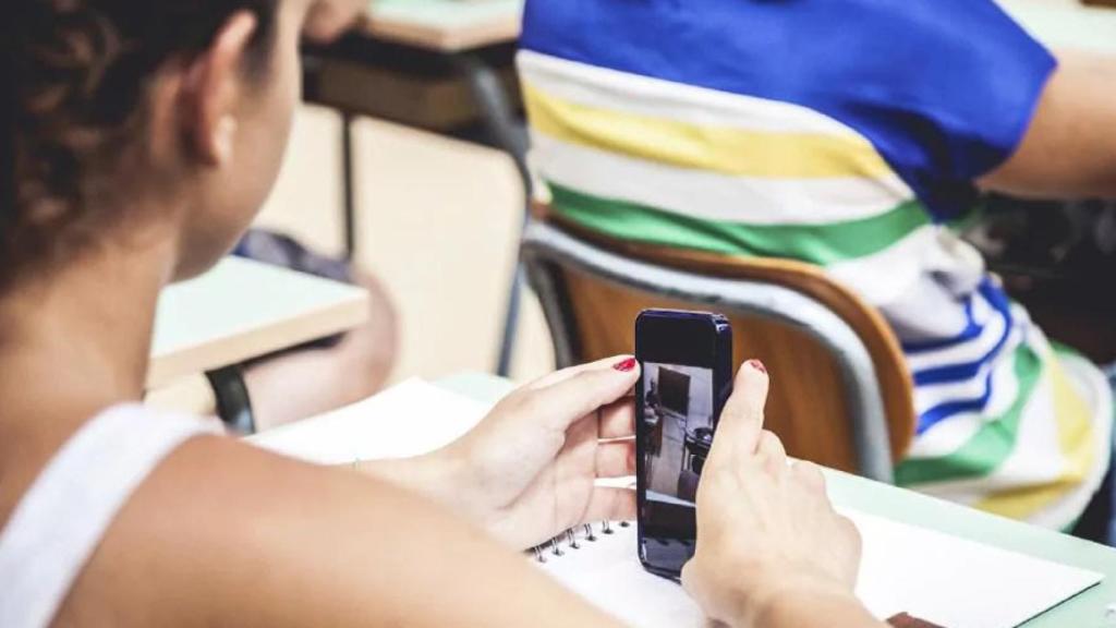 Una adolescente usando el móvil en clase