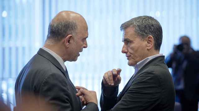 El comisario Moscovici conversa con el ministro griego Tsakalotos durante el Eurogrupo