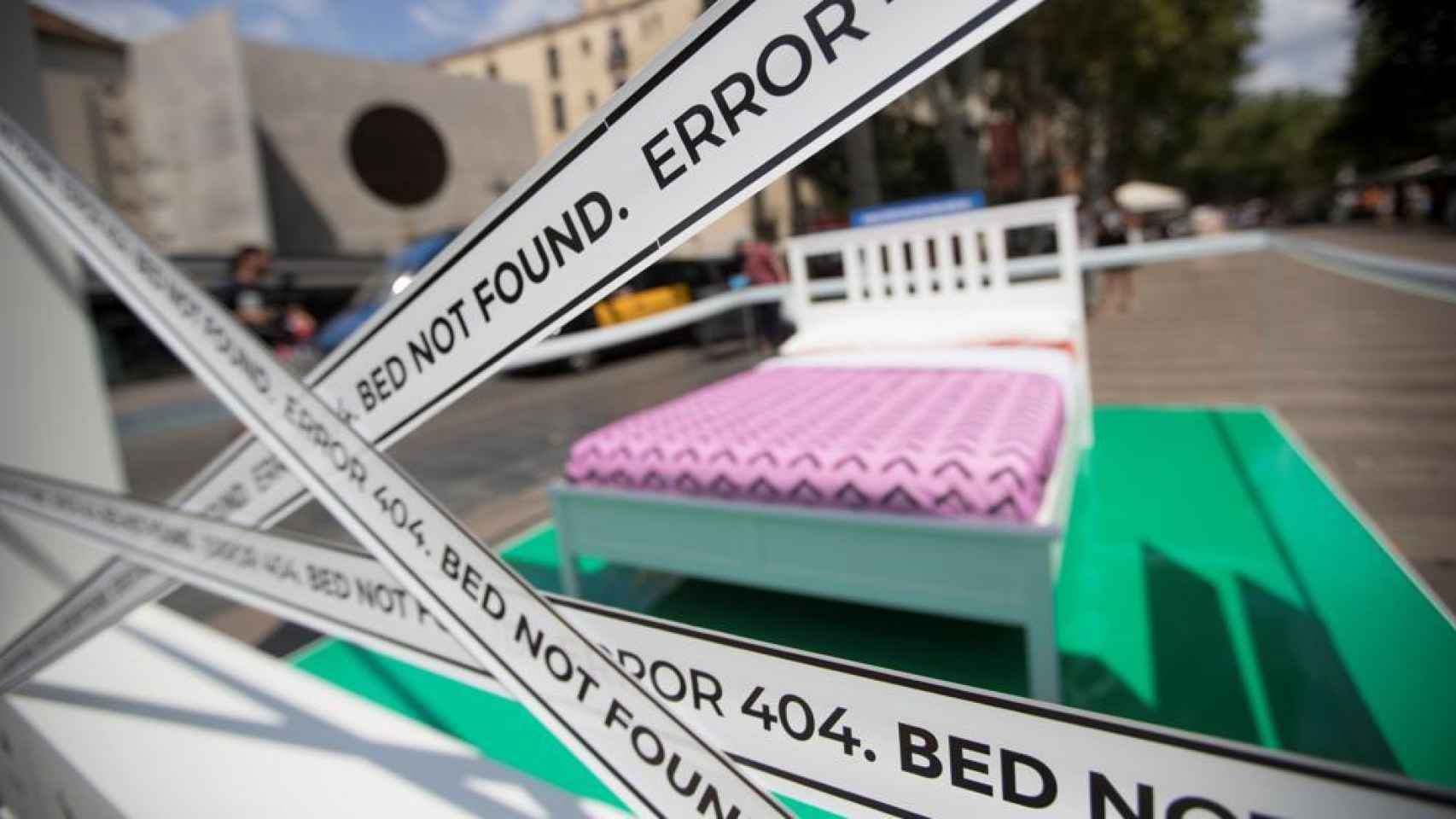 Una cama instalada por el Ayuntamiento de Barcelona en la calle para indicar que hay pisos ilegales funcionando en la zona.