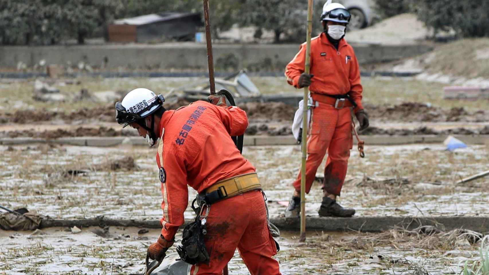 Miembros de los servicios de rescate buscan personas desaparecidas en una zona cubierta de lodo en la localidad de Kurashiki, al oeste de Japón.