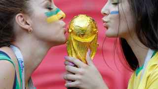 Dos chicas besan la Copa del Mundo en un estadio de Rusia.
