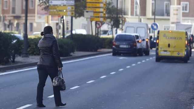 Una mujer cruzando por el medio de la calle.