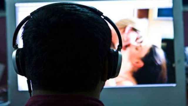 Un usuario delante de la pantalla del ordenador viendo un vídeo porno.