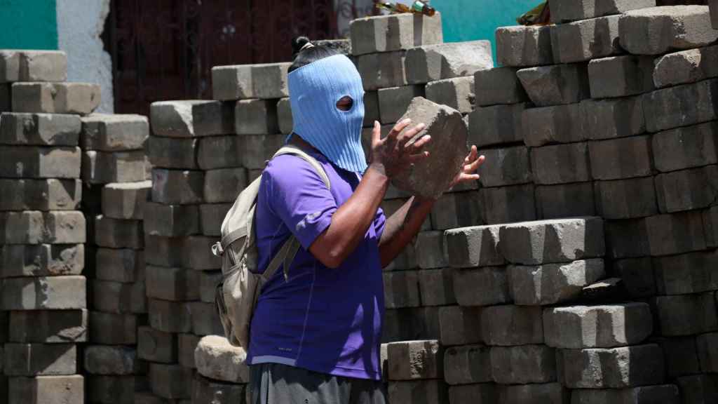 Un ciudadano de la comunidad indígena de Monimbó prepara una barricada.