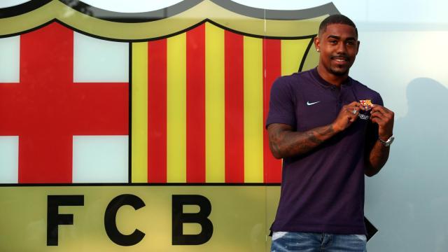 Brazilian soccer player Malcom Filipe Silva de Oliveira poses in front of a FC Barcelona logo at their offices next to Camp Nou stadium in Barcelona