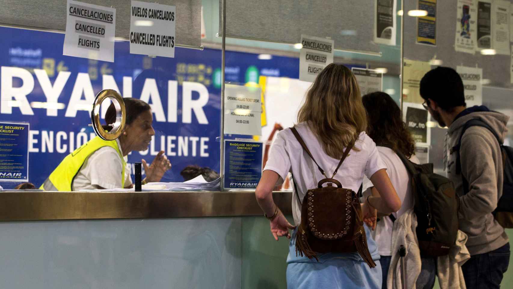 Varios pasajeros consultan información en el mostrador de Ryanair en El Prat.