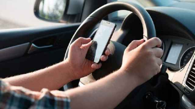 Un conductor utilizando el móvil mientras conduce.