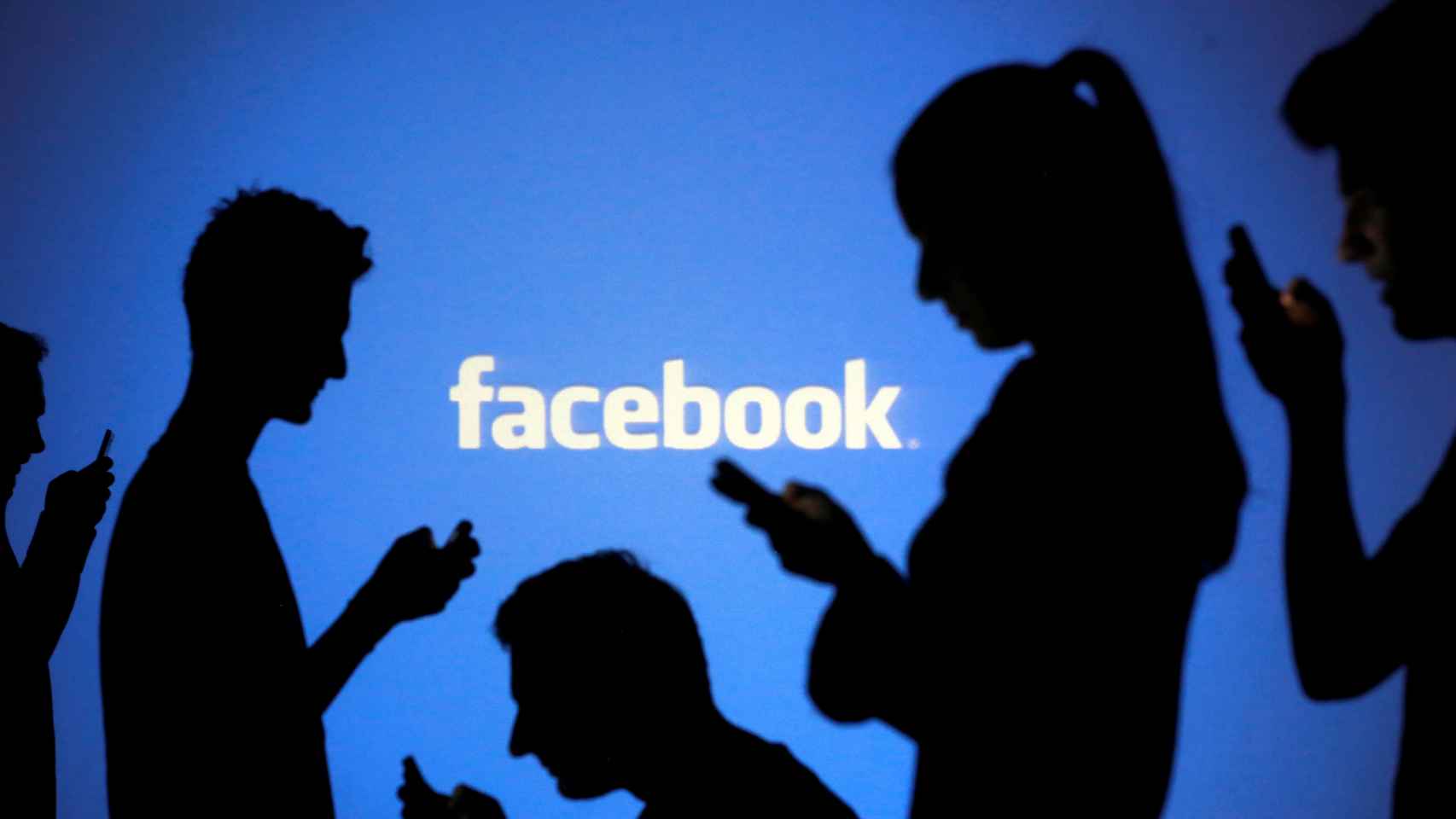 Ilustración de gente consultando sus dispositivos móviles frente al logotipo de Facebook.