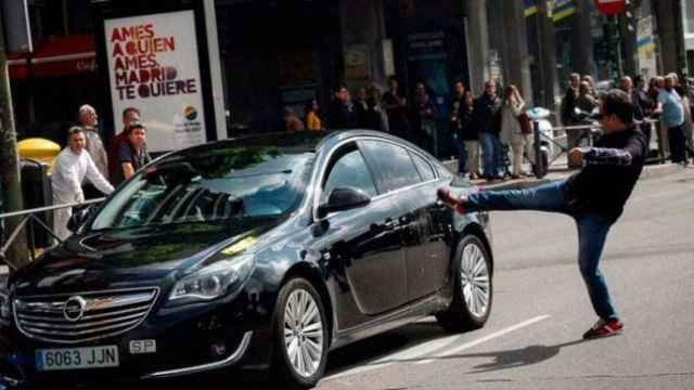 Un taxista en huelga propina una patada a un coche con licencia VTC en Madrid