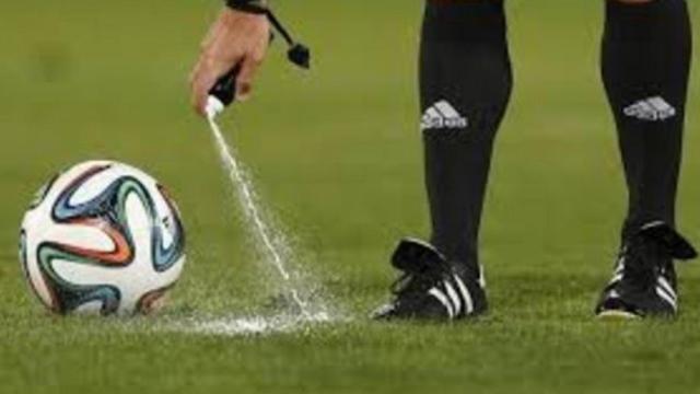 Un árbitro utiliza el spray para marcar el lugar de una falta.