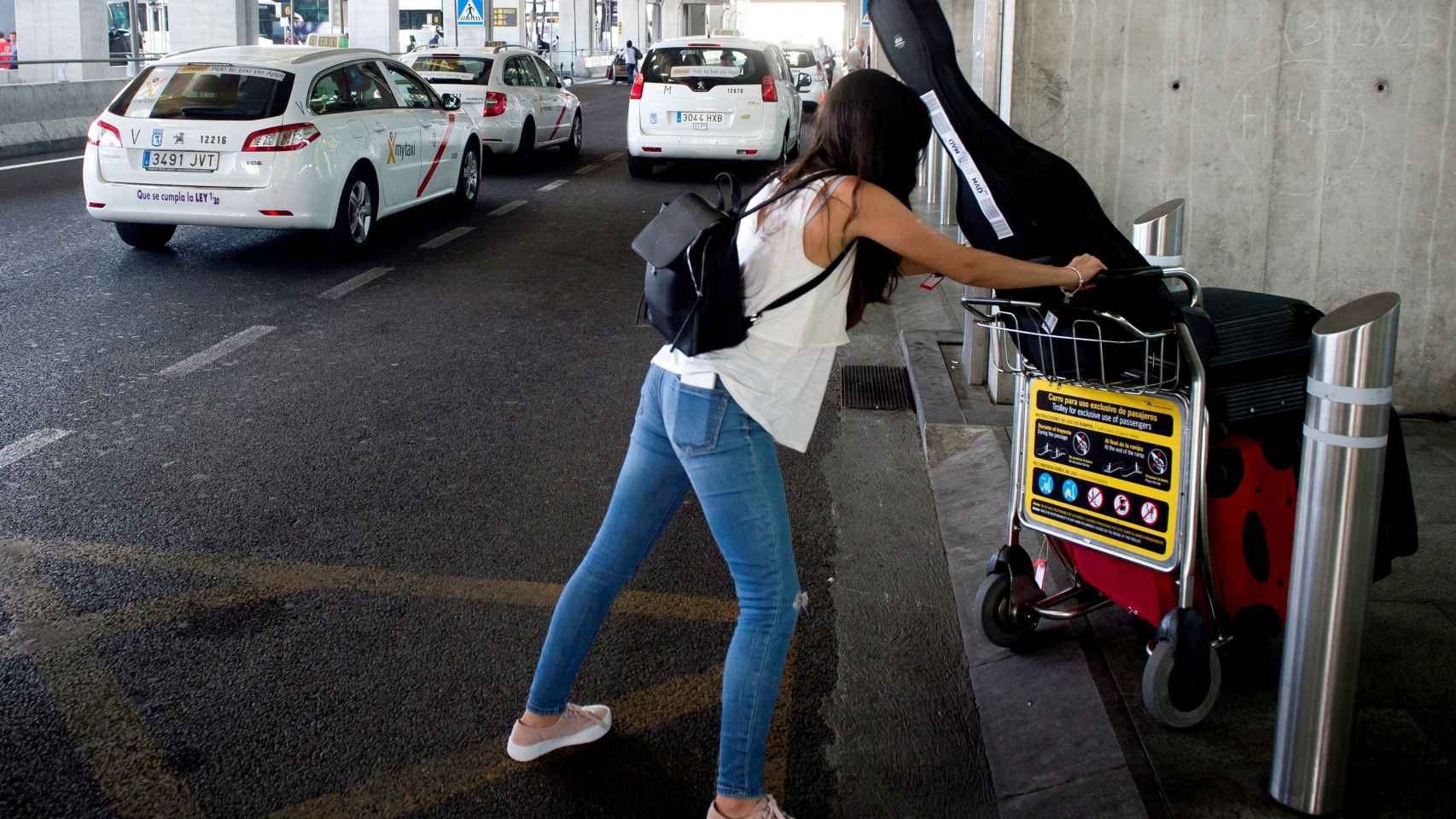 Una usuaria en Barajas carga con su equipaje en plena huelga de taxis.
