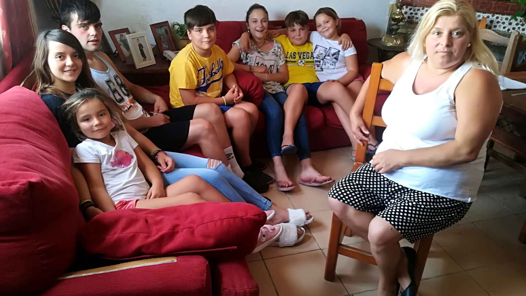 Paqui, sentada en una silla, y los siete nietos que le entregó la Junta de Andalucía en régimen de acogida en agosto de 2011, después de que la madre se desentendiera de ellos.