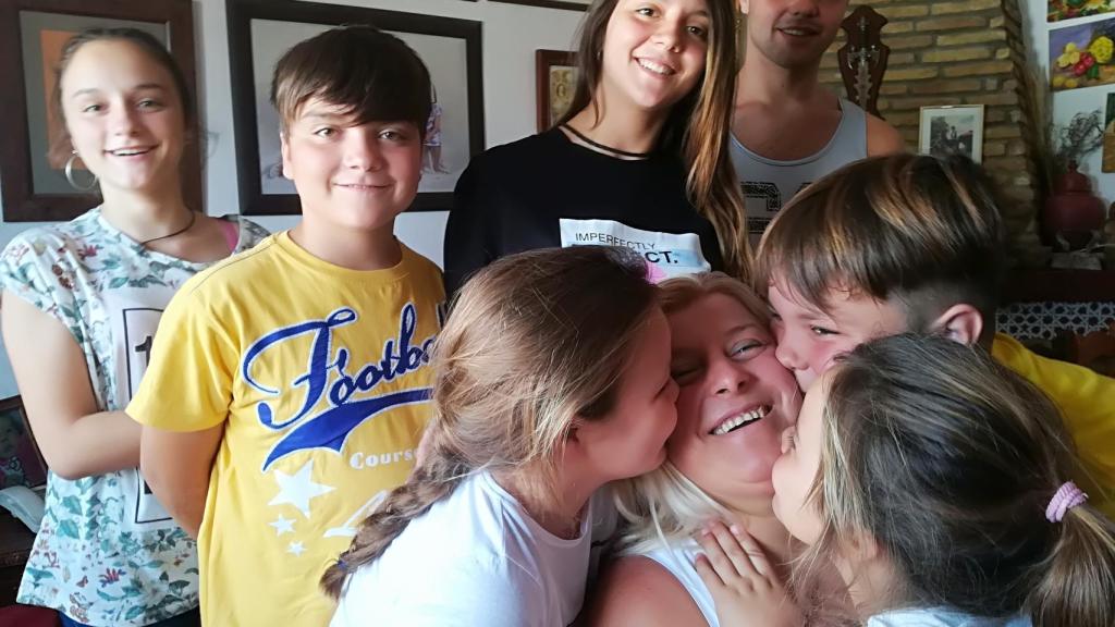 Paqui recibe el beso de tres de sus nietos.