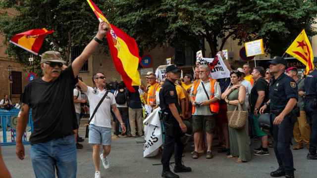 Dos constitucionalistas ondean banderas de España frente a los independentistas.