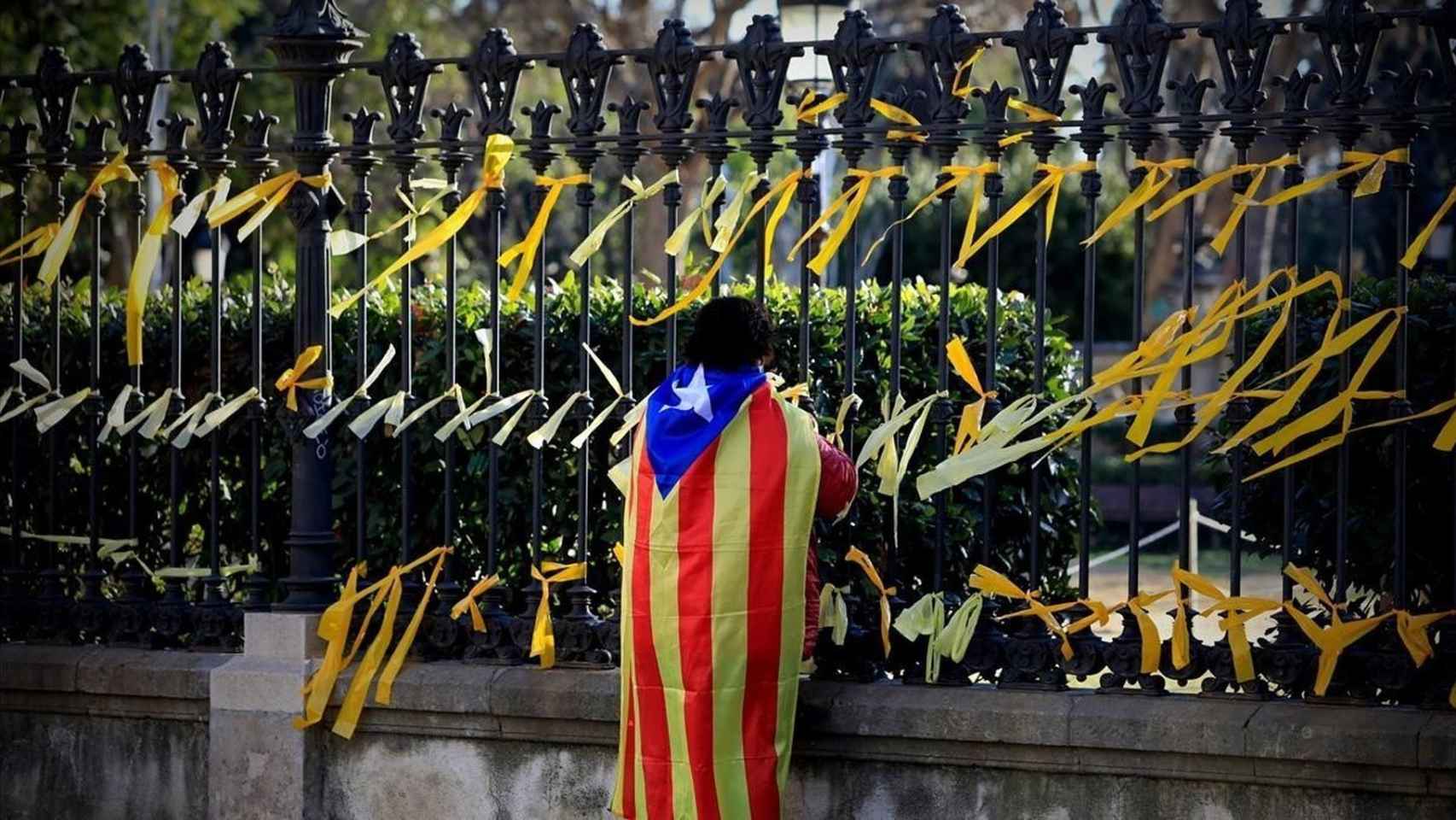 Un independentista coloca lazos amarillos en Barcelona.