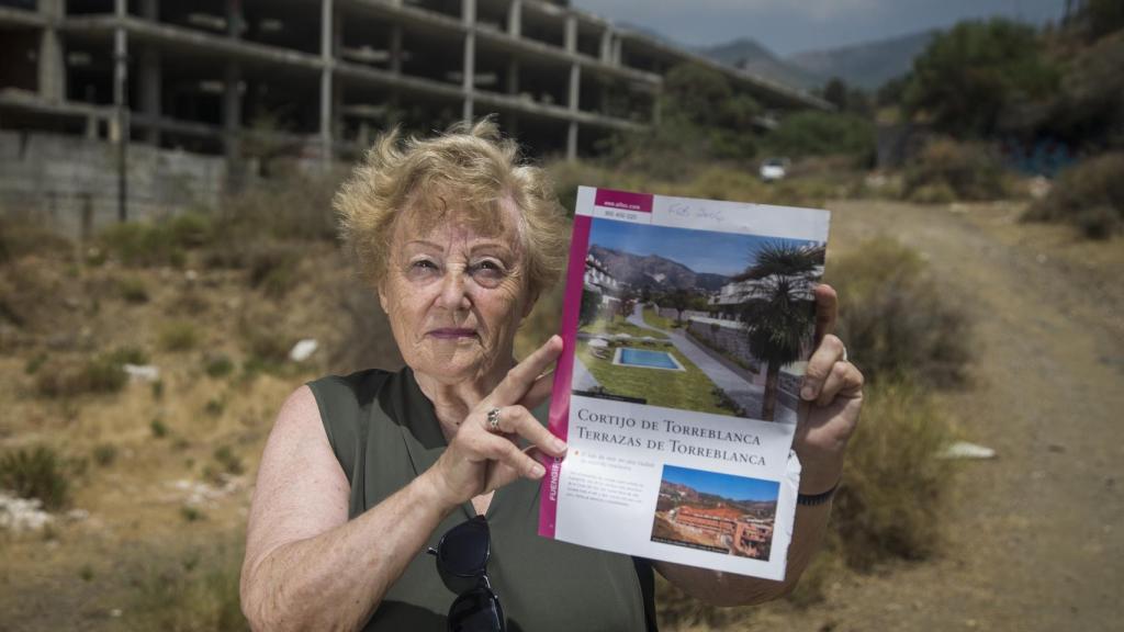 La ciudadana británica Ángela Jhon muestra el dossier que le entregaron al dar la entrada de un apartamento en la promoción Cortijo de Torreblanca. Foto Fernando Ruso