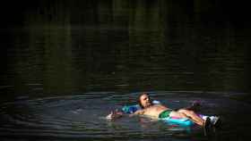 Un hombre se refresca en el río Arga a su paso por Pamplona.