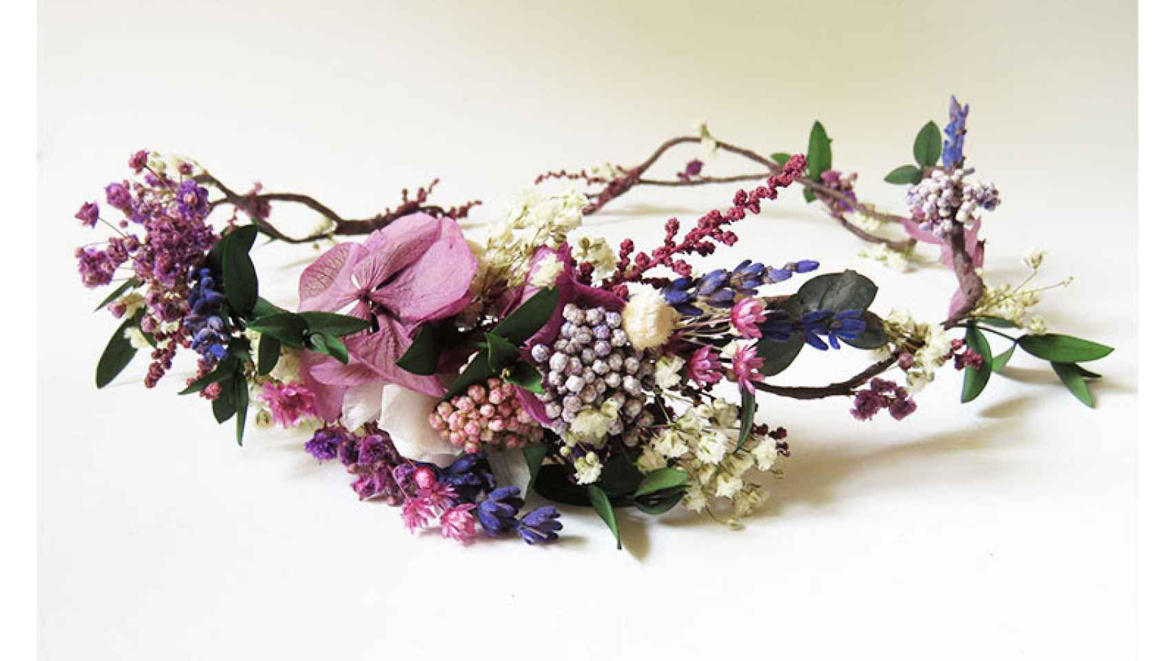 Corona de flores en tonos lila de 'El Taller de Bagatela'.