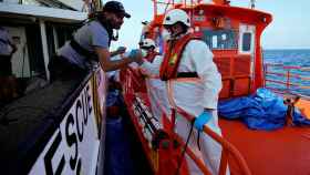 Un efectivo de Salvamento Marítimo saluda a un miembro de Open Arms en alta mar