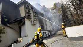 Dos bomberos refrescan en interior de una de las viviendas afectadas por el incendio forestal de Llutxent.