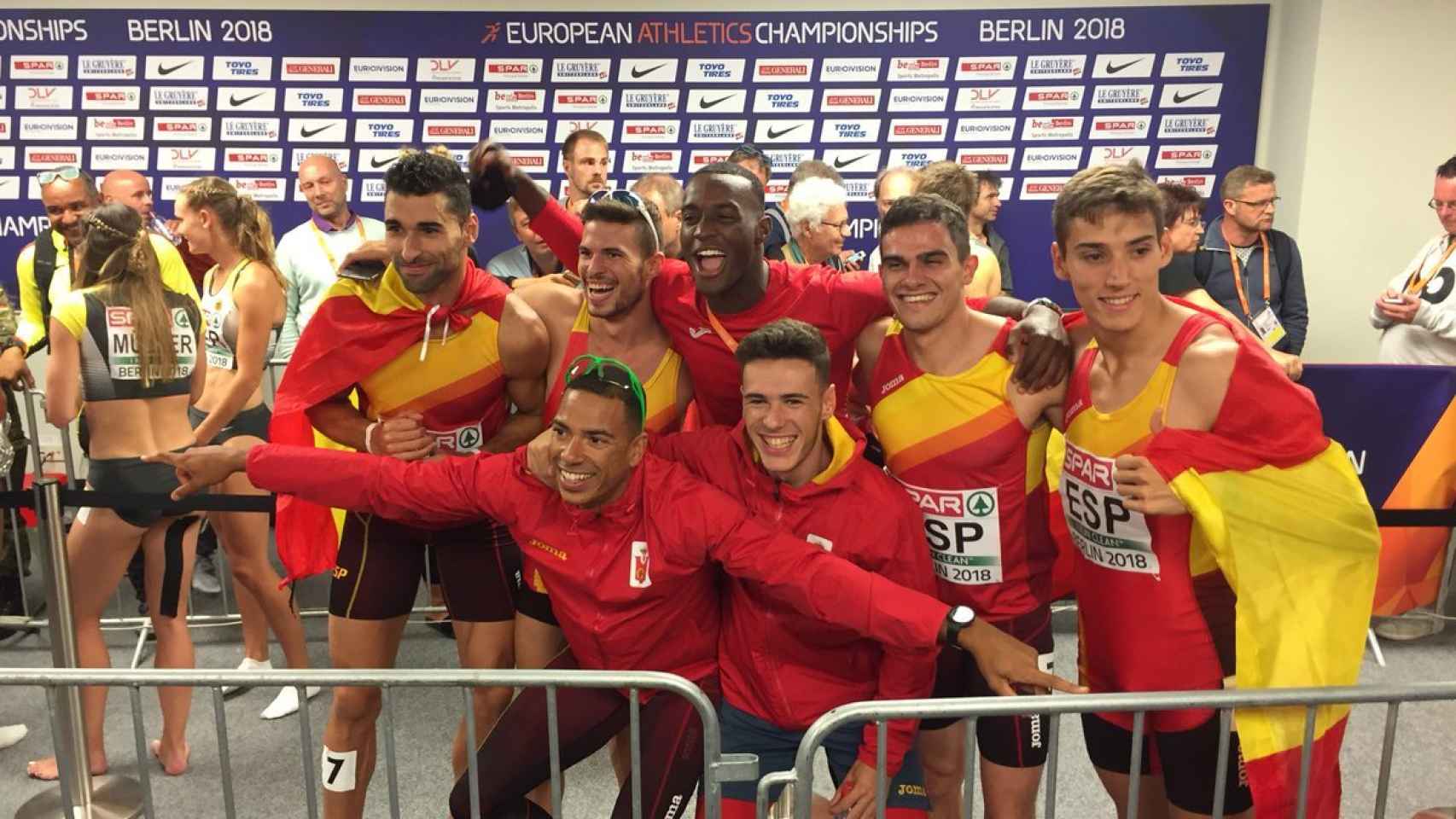 Los siete integrantes del 4x400m celebran el bronce en zona mixta.