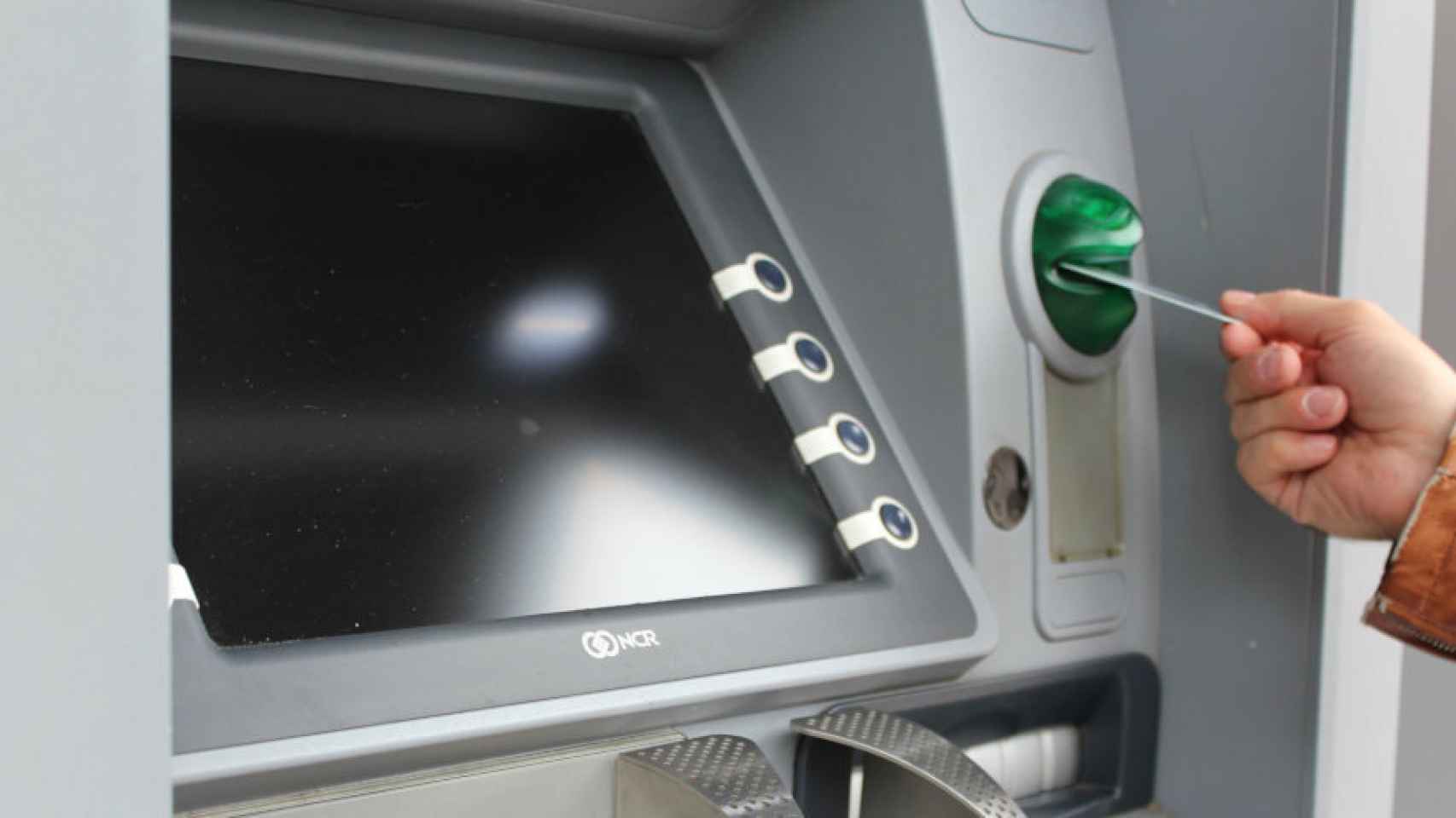 Un usuario introduce su tarjeta de crédito en un cajero automático.