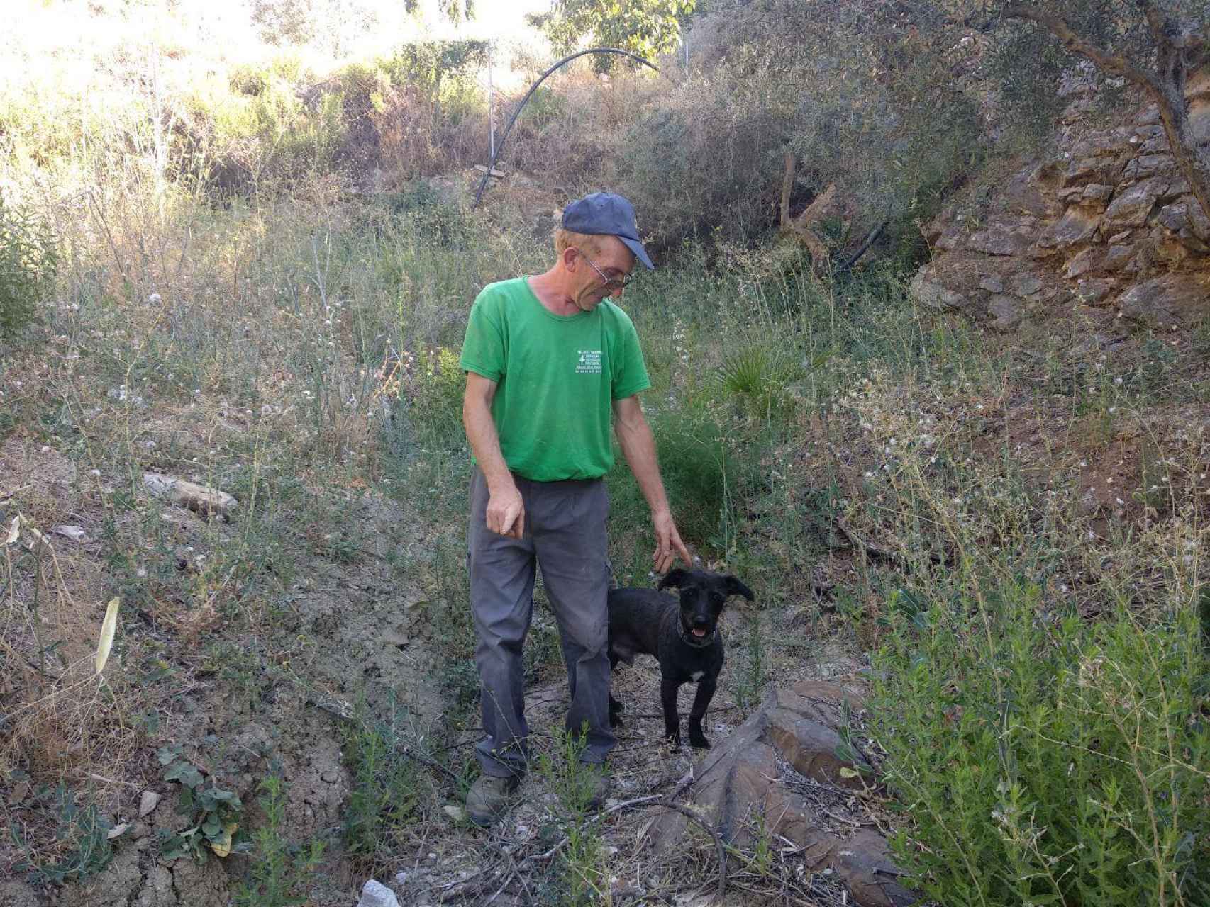 Pedro, el dueño de la finca, señala el lugar exacto en el que se encontró el cadáver: la piedra en la que se asienta, en ese momento, su perro. FOTO: BORJA DÍEZ