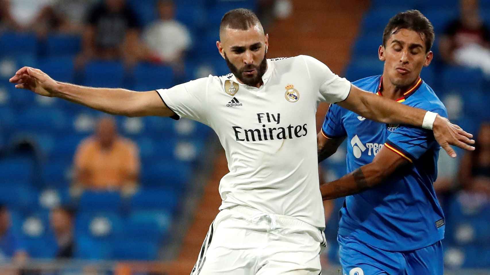 Karim Benzema, pugna por un balón con un jugador del Getafe.
