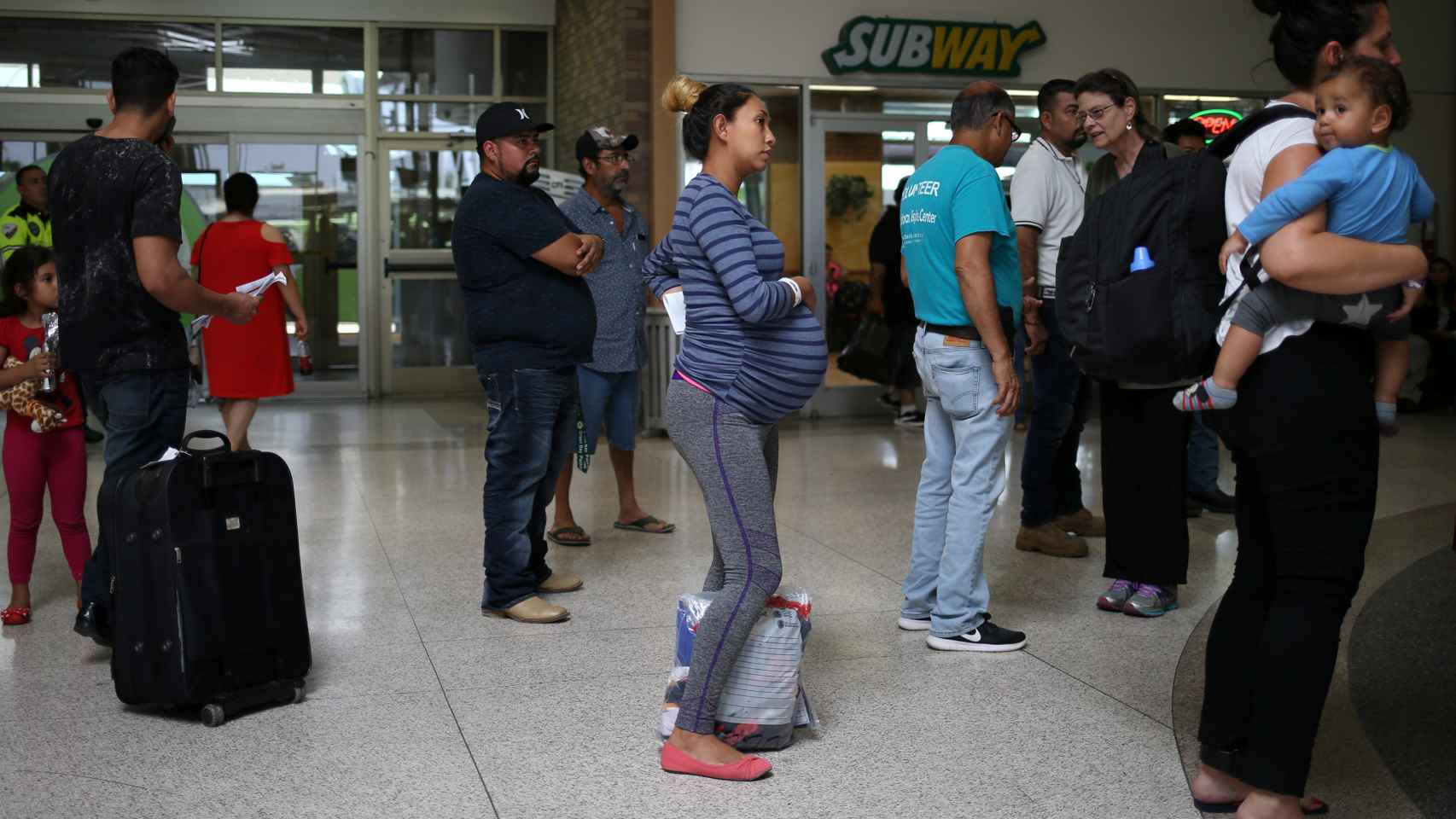 Una mujer embarazada, junto a otros inmigrantes, en la estación de autobuses de Texas.