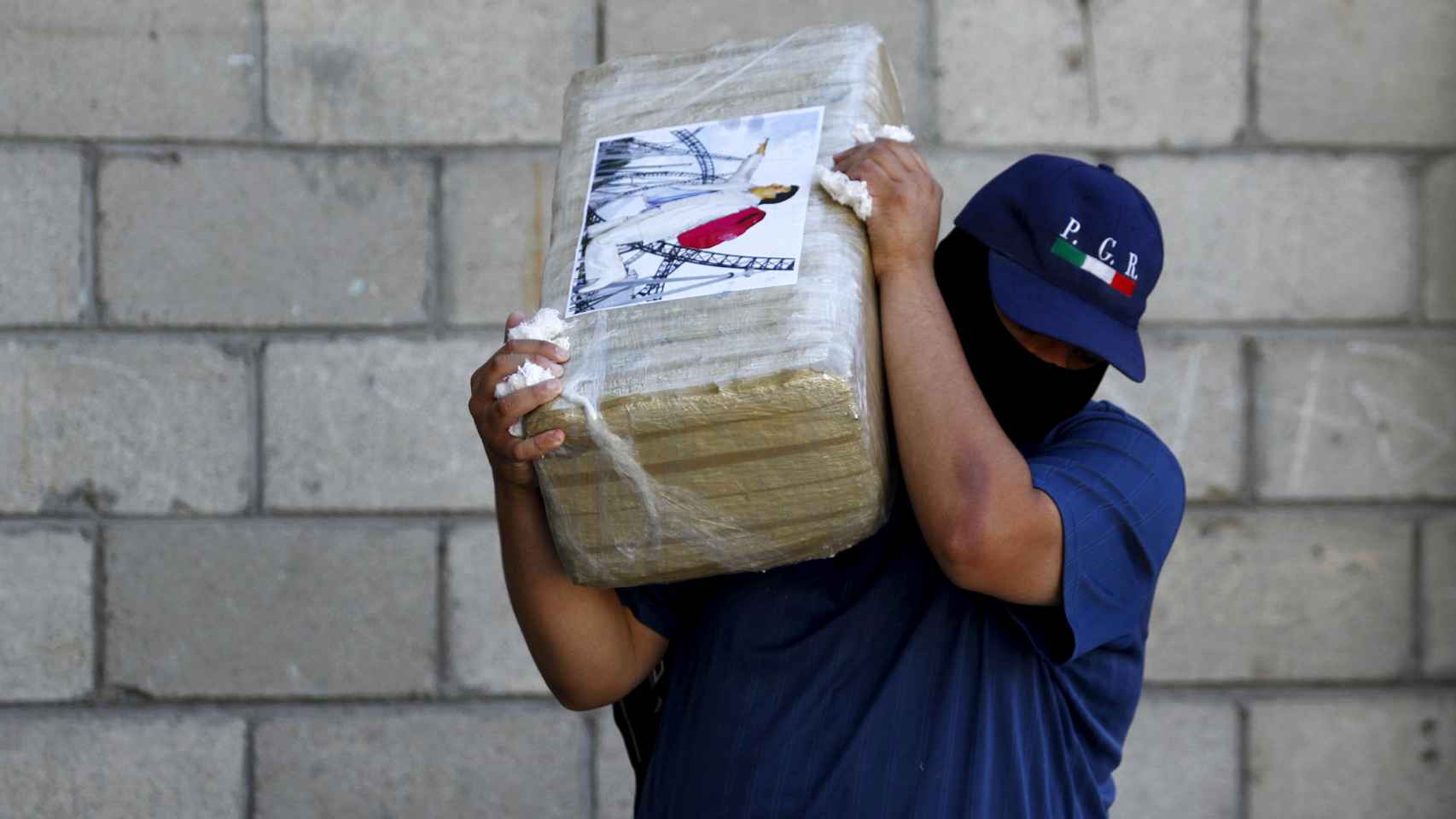 Un agente carga un fardo de droga incautado al cartel de 'El Chapo'.