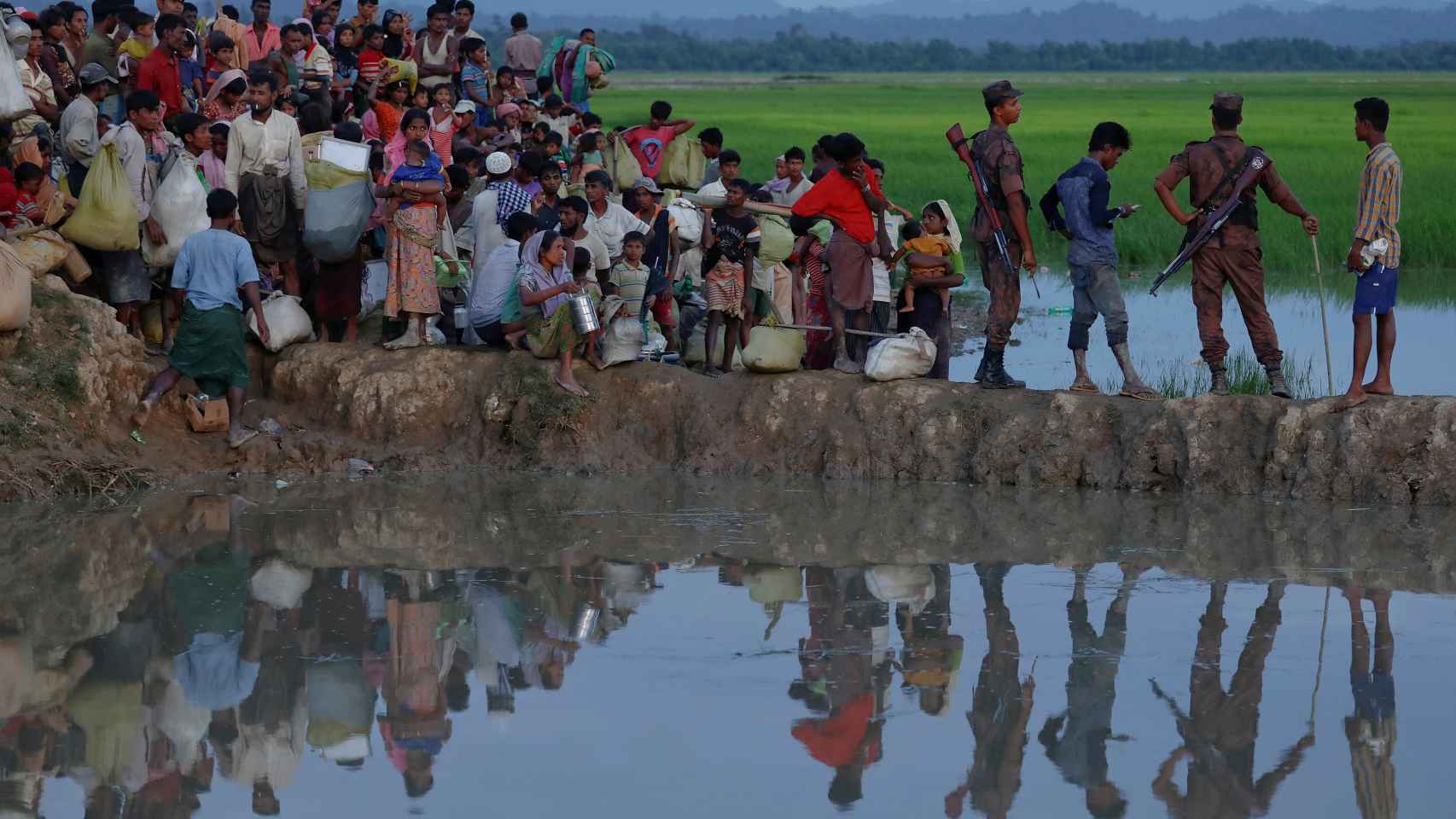 Los refugiados rohingya esperan en un campo de arroz tras cruzar la frontera en Palang Khali.