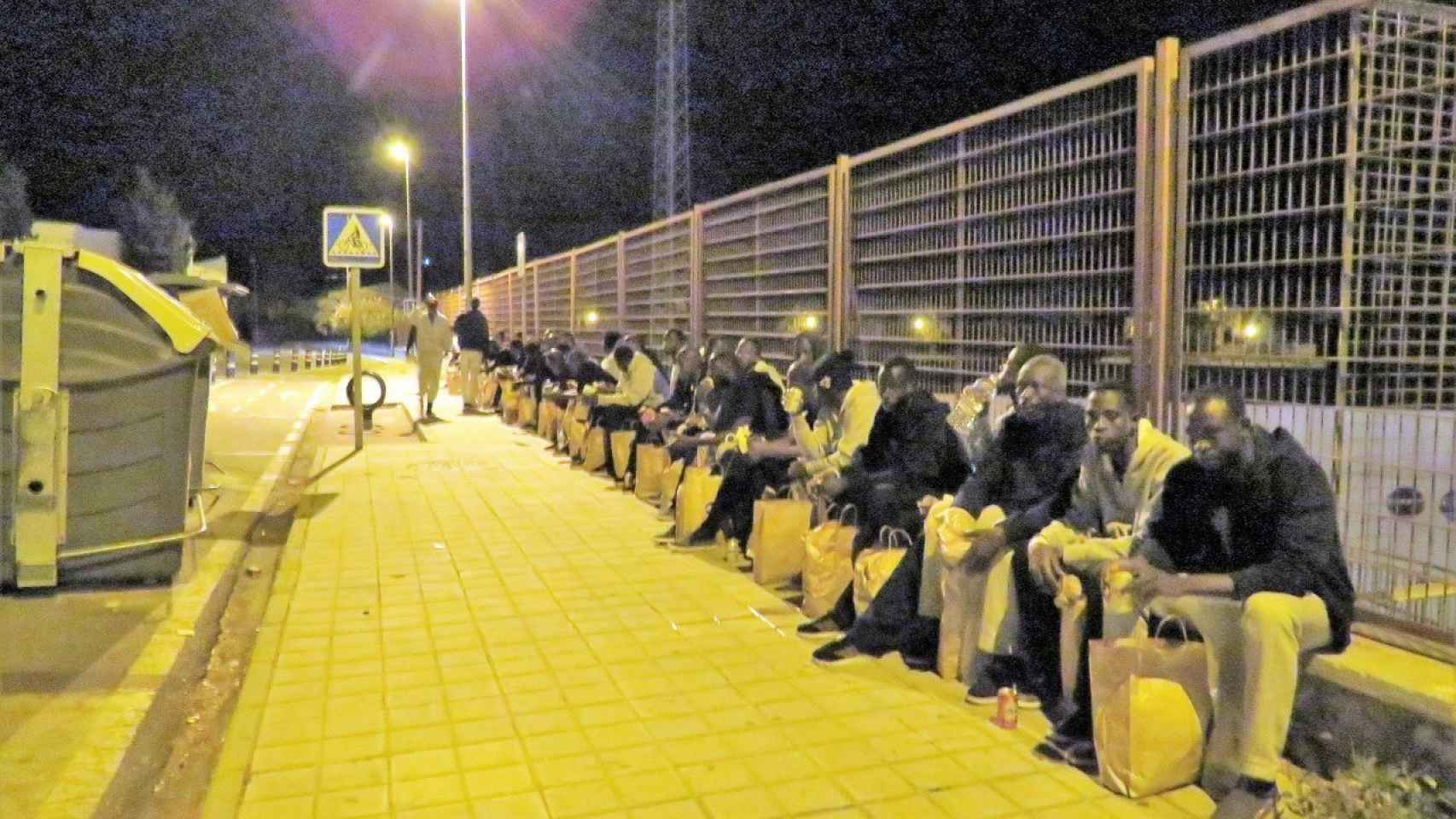 Los migrantes esperando al 'bus de la vergüenza' esperando.