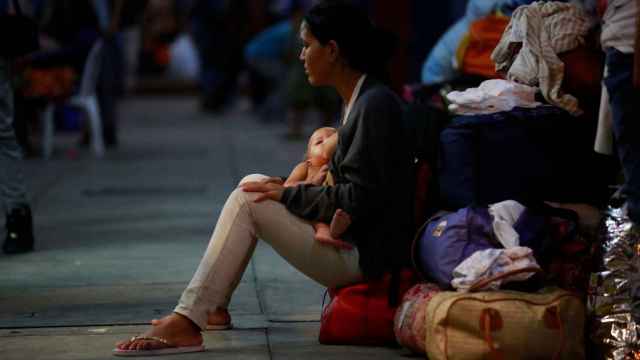 Una mujer venezolana espera con su bebé en el Centro Binacional de Atención en Frontera de Perú