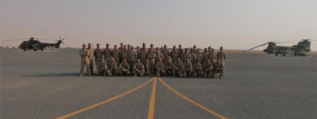La comandante Gala Gallego posa junto a parte de sus efectivos y los helicópteros españoles en Irak.