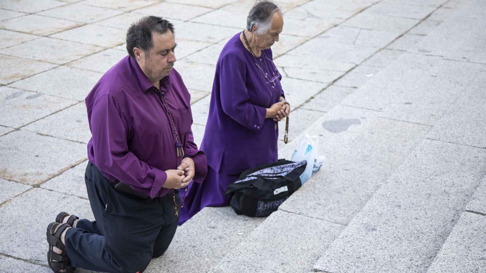 Dos religiosos rezando en las escaleras del valle durante el acto.