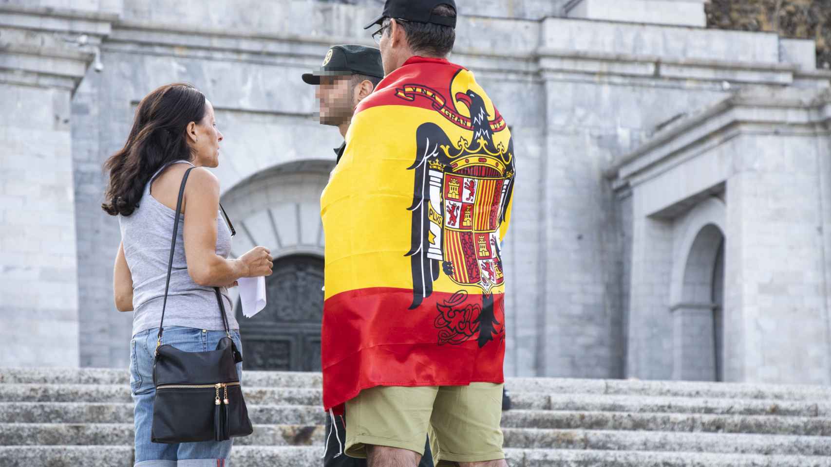 Uno de los asistentes a la vigilia del Valle de los Caídos luce la bandera franquista.