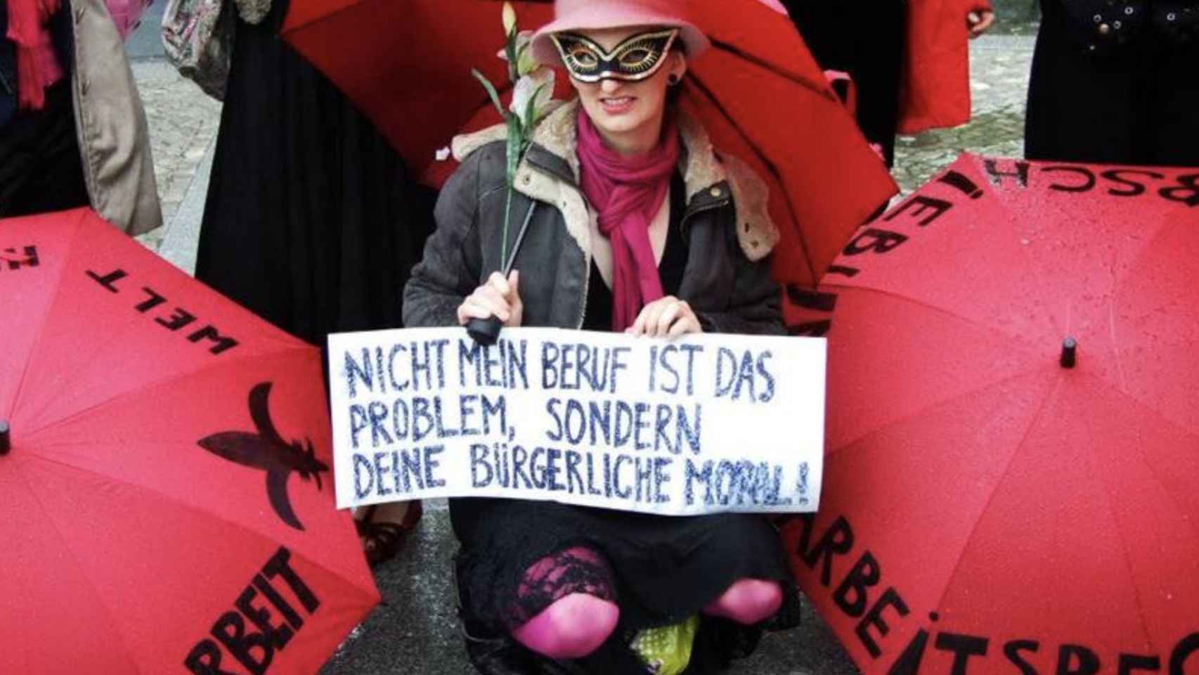 Alexa sosteniendo un cartel protesta: Mi trabajo no es el problema, sino tu moralidad burguesa.