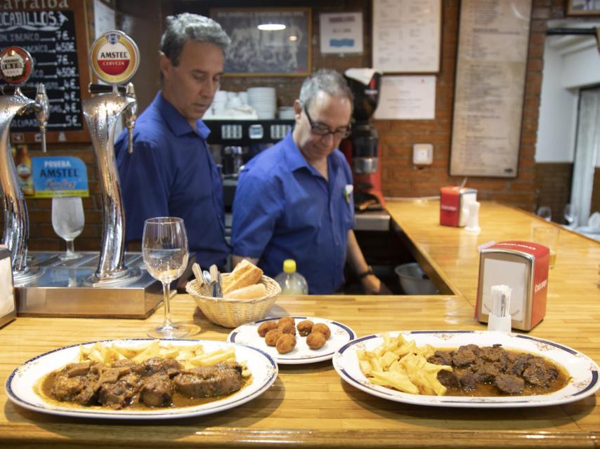 Antonio y Carlos trabajan tras la barra. En la barra, de izquierda a derecha: rabo de toro y canguro.