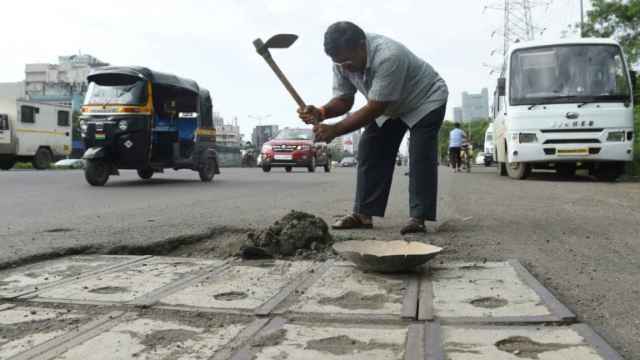 Dadarao Bilhore tapando algunos agujeros de la carretera.