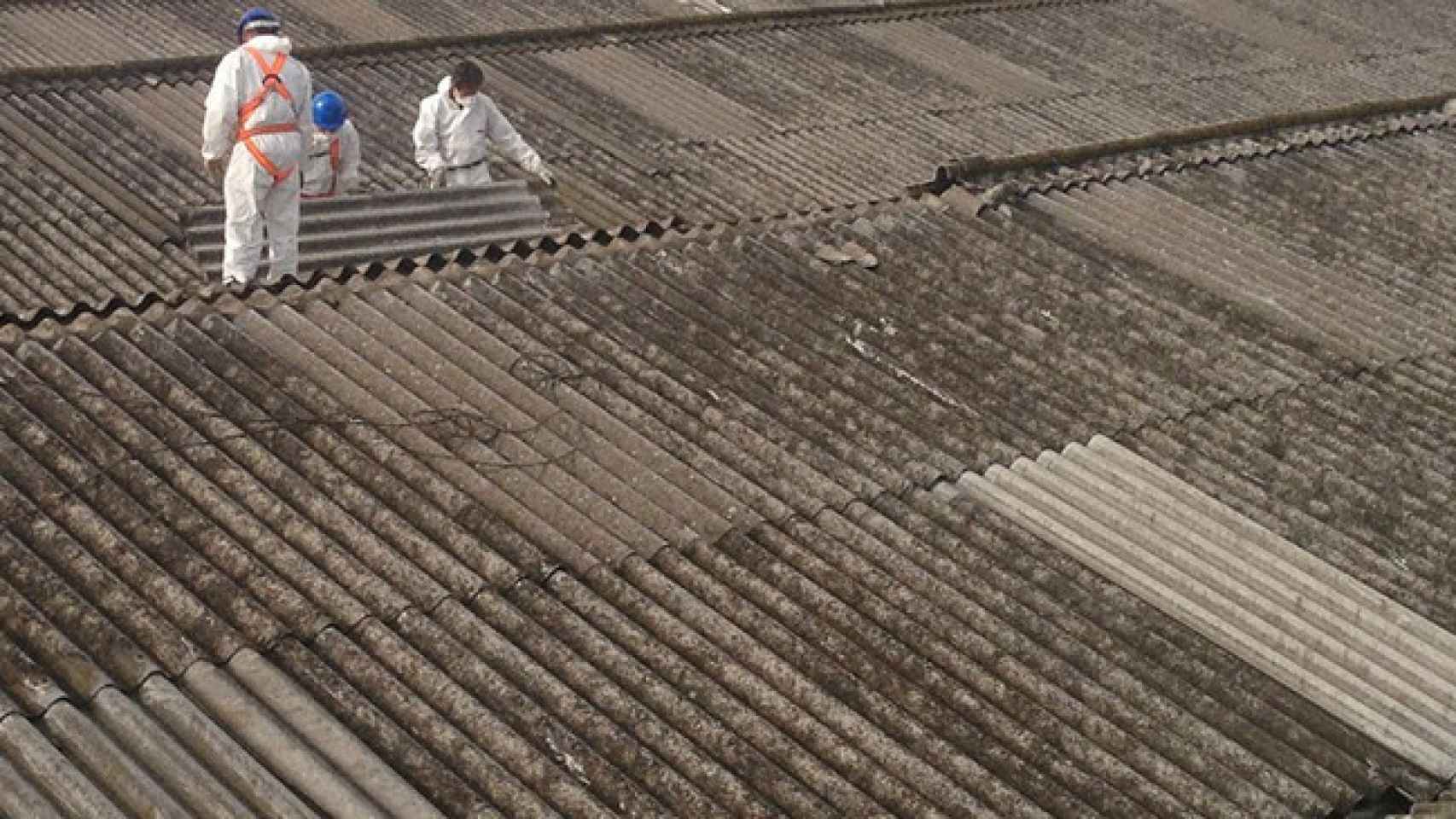 Desde 2002, en España está prohibido el uso de amianto, que solía usarse para techados. En la imagen, dos operarios retirando un tejado de uralita