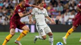Luka Modric, defendido por un jugador de la Roma
