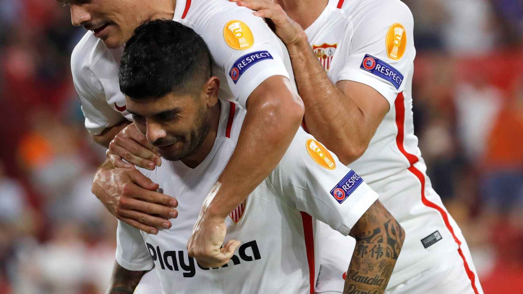 Roque Mesa y Sergi Gómez abrazan a Banega tras su gol en el Sevilla - Standard de Lieja
