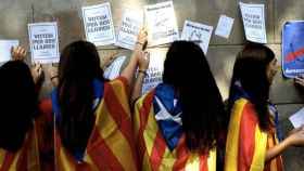 Escolares catalanes pegan carteles a favor de la independencia.
