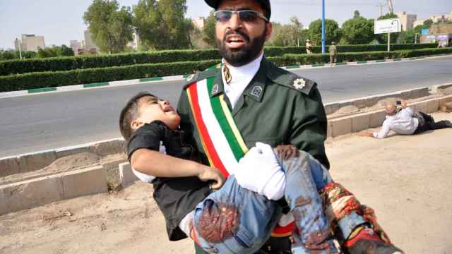 Un soldado iraní carga en brazos con un niño que resultó herido en el atentado terrorista en Irán.