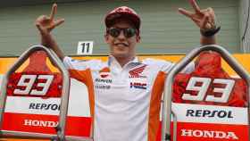 Marc Márquez posa con gesto victorioso a las puertas del box del equipo Repsol Honda.