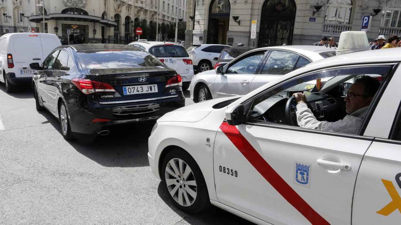 Un taxi detrás de un vehículo VTC en Madrid.