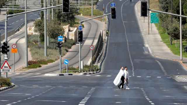 Dos peatones cruzan una carretera en Jerusalén.