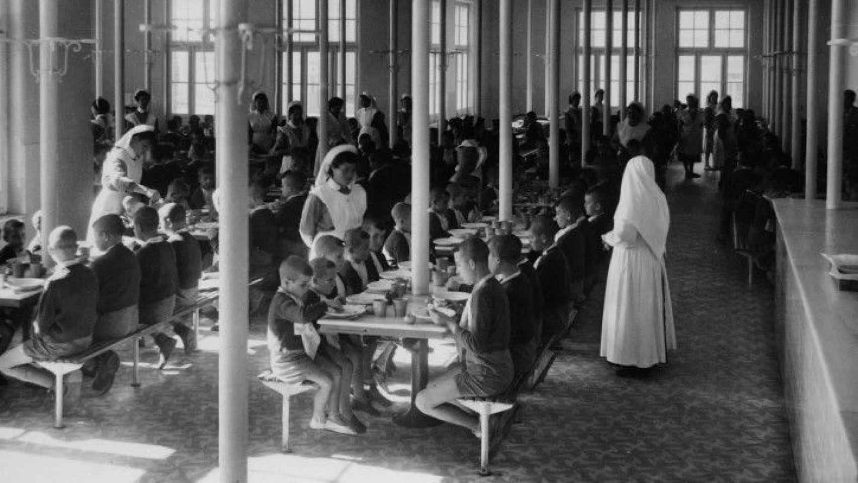 Un grupo de niños almuerza en un convento de monjas en la época del franquismo.
