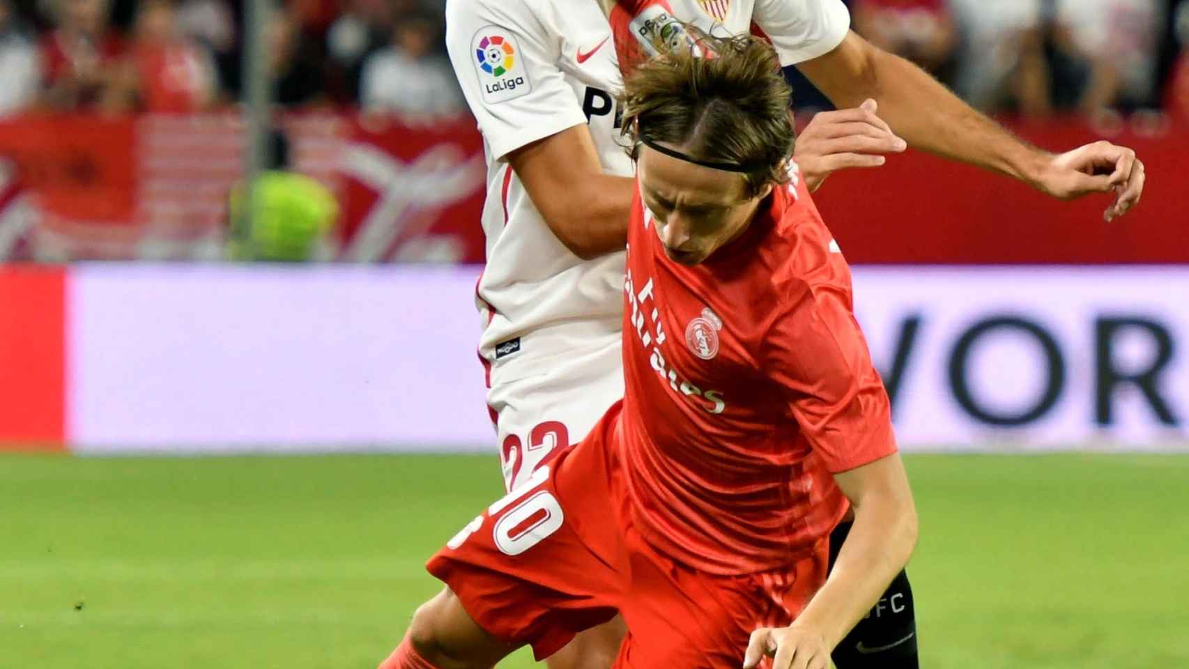 Luka Modric derribado por un jugador del Sevilla